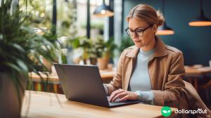A woman with glasses working on her laptop to prepare her resume.