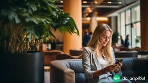 A well dressed self employed entrepreneur texting on her phone in a hotel lobby, waiting to meet with a client.